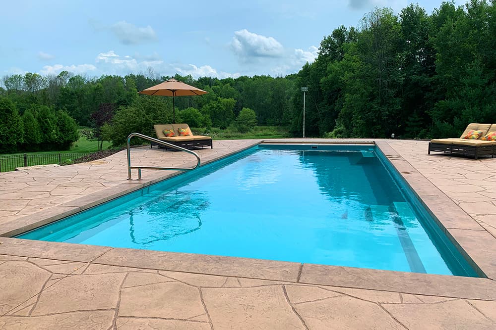 IllusionGallery-40CoralBlue-02 Beautiful view from the water’s edge. The still water allows for view of the splash pad, steps, and benches.
