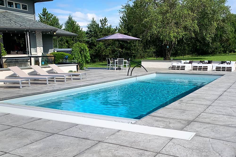 IllusionGallery-40IceSilver-02 Sleek modern fiberglass pool with plenty of lounging area. Colored and stamped concrete to compliment the pool and furniture.